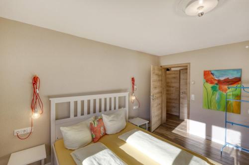 a bedroom with a bed and a painting on the wall at Gasthaus Schwanen & Villa Pfarrhus in Stühlingen