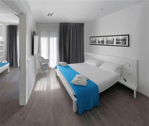 a bedroom with a large bed with a blue blanket at Hotel Europa Monetti in Cattolica
