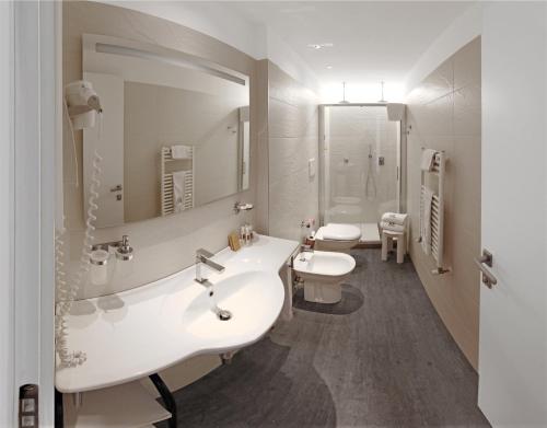 a bathroom with two sinks and a large mirror at Hotel Europa Monetti in Cattolica