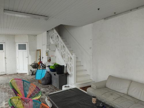 a living room with a couch and a staircase at appartement individuelle refais a neuf,ds maison de maître,6 couchages dont un lit kingsize,cuisine avec lave vaisselle,rue privative pour se garer, accessibilité au jardin in Le Havre