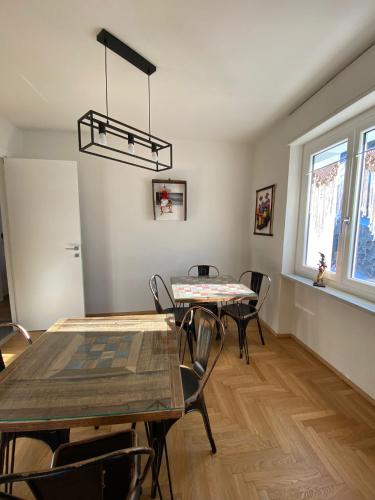 a dining room with tables and chairs and a chandelier at Chèvres à Cheval - Apartment in Aosta