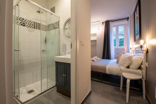 a bathroom with a bed and a shower and a sink at LE MADAMINE ROOMS in Turin