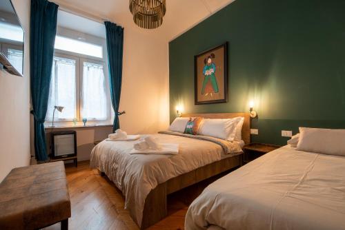 two beds in a room with green walls at LE MADAMINE ROOMS in Turin