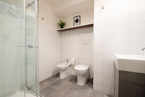 a bathroom with a toilet and a sink and a shower at LE MADAMINE ROOMS in Turin