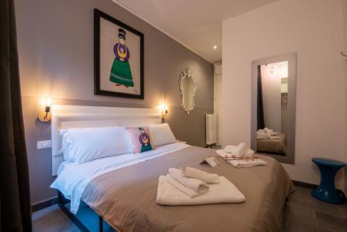 a bedroom with a bed with towels on it at LE MADAMINE ROOMS in Turin
