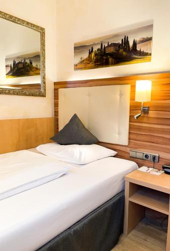 a hotel room with two beds and a desk at City Hotel Ost am Kö in Augsburg
