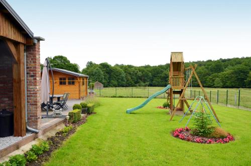einen Garten mit Rutsche und Spielplatz in der Unterkunft Gîte Le petit coin de paradis Sautin in Montbliart