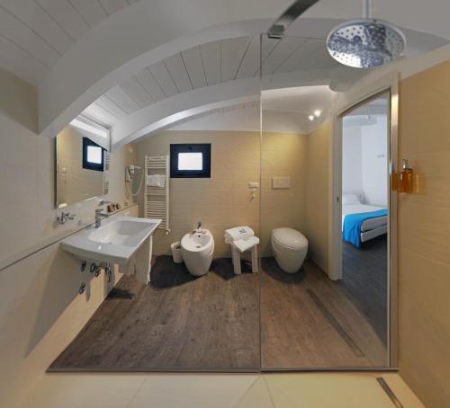 a bathroom with a sink and a toilet and a bed at Hotel Europa Monetti in Cattolica
