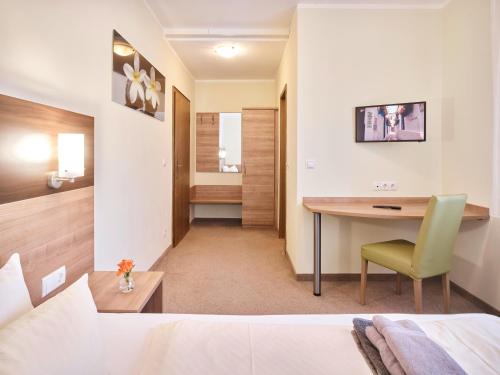 Habitación de hotel con escritorio y cama en Portofino en Bonn