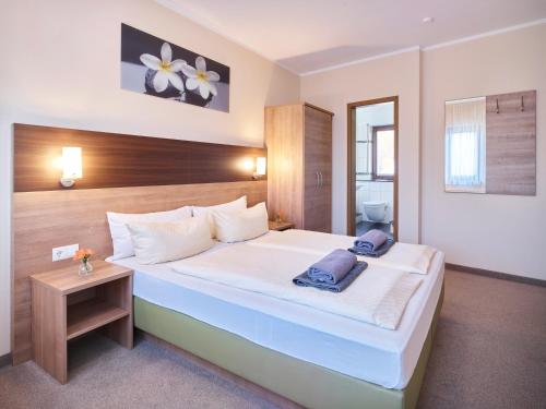 a bedroom with a large white bed with a wooden headboard at Portofino in Bonn