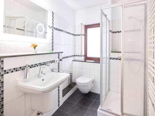 a white bathroom with a sink and a toilet at Portofino in Bonn