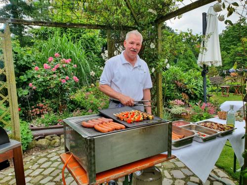 an older man is cooking carrots on a grill at Heitmann`s Gasthof in Kirchlinteln