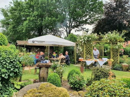 a group of people sitting at tables in a garden at Heitmann`s Gasthof in Kirchlinteln