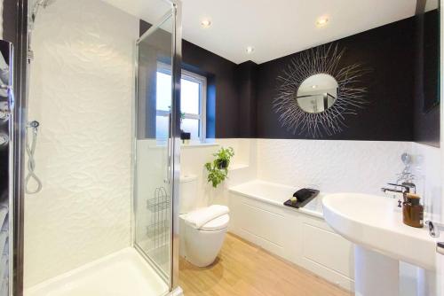a bathroom with a shower and a toilet and a sink at Stunning 4 Bed House with Cinema Room & Parking in Manchester