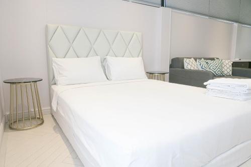 a bedroom with a large white bed and a couch at Comfy Studio 7 by ReCharge in Singapore