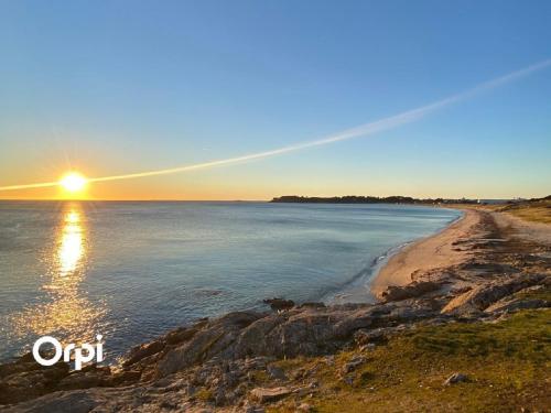 a beach with the sun setting over the water at REF 146 Appartement pour quatre personnes jolie vue Port Crouesty ARZON in Arzon