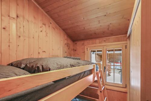 sypialnia z 2 łóżkami piętrowymi i oknem w obiekcie Charmant Chalet dans la montagne proche de Verbier w mieście Sembrancher