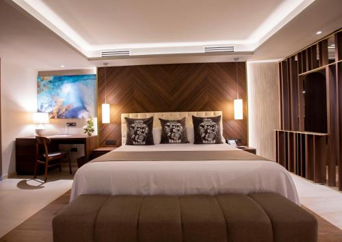 sypialnia z dużym łóżkiem i biurkiem w obiekcie Panafrica Hotel Boutique & Spa w Bacie