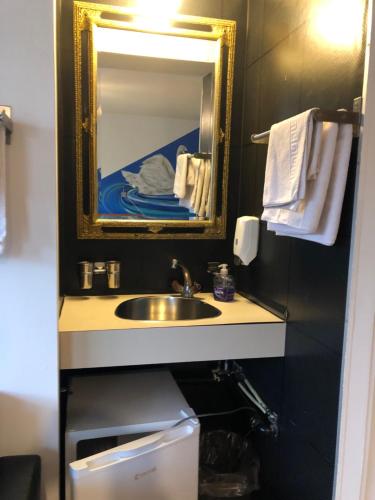 a bathroom with a sink and a mirror at Oldtown Hostel Otter in Zürich