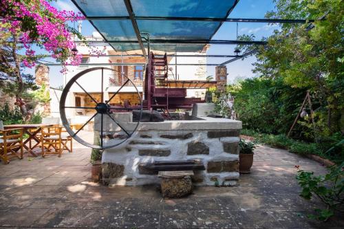 a patio with a stone fountain with a table and chairs at Mansion Argyrakiko - 3 bedroom house in Kampos in Chios