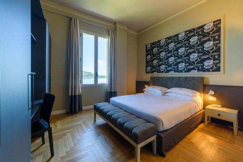 a bedroom with a bed and a large window at Hotel Villa Paradiso in Arona