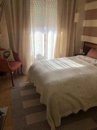 een slaapkamer met een wit bed en een raam bij Family-Appartment in Santa Pola