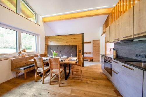 Bergblick Apartment في والد ام بينزاغو: مطبخ مع طاولة وكراسي خشبية في الغرفة