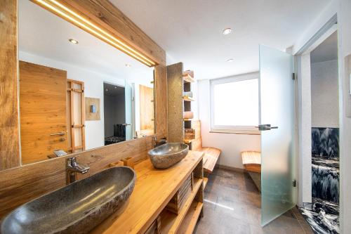 - une salle de bains avec deux lavabos sur un comptoir en bois dans l'établissement Bergblick Apartment, à Wald im Pinzgau