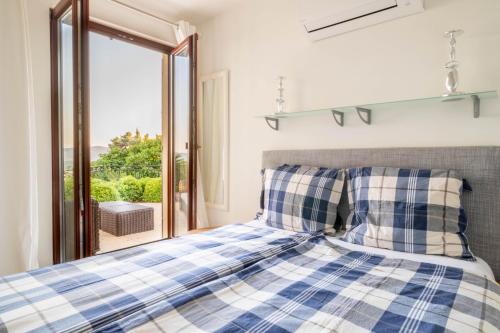 una camera con un letto blu e bianco e una finestra di Villa Gai Coteau a Le Lavandou