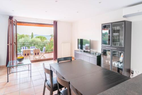 una cucina e una sala da pranzo con tavolo e TV di Villa Gai Coteau a Le Lavandou