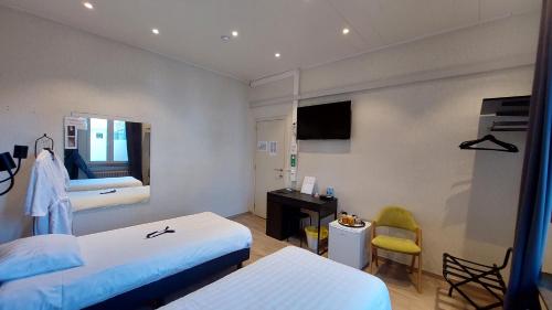 Habitación de hotel con 2 camas y escritorio en Albert - Rooms en Mechelen