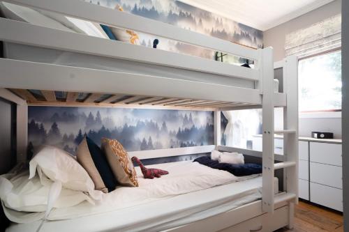 een slaapkamer met een stapelbed met witte stapelbedden bij Kinloch Lodge in Bearnock