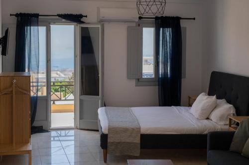 a bedroom with a bed and a balcony at K & G Central Apartments Fira in Fira