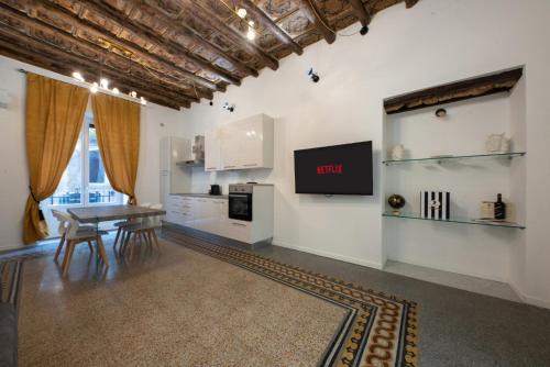 a kitchen with a table and a tv on a wall at Casta Diva Luxury Apartments in Palermo