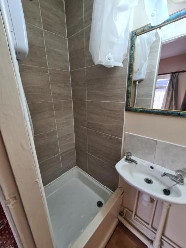 a bathroom with a tub and a sink and a mirror at The Coach House in Kegworth