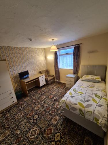 a bedroom with a bed and a desk and a window at The Coach House in Kegworth