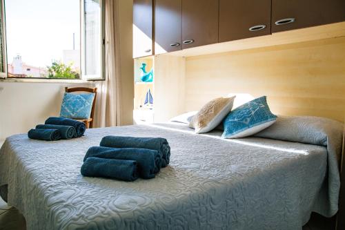 a bedroom with a bed with blue towels on it at Lungomare Bay, e sei in spiaggia... in Cala Gonone