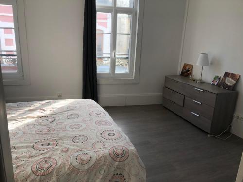 una camera con letto, cassettiera e finestre di Sandra a Berck-sur-Mer