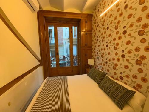 een kleine slaapkamer met een bed en een raam bij El Jardín del Ángel Olivo in Madrid