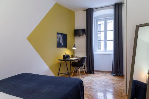 a bedroom with a bed and a desk with a window at Appartamento Nuovissimo Per 4 Ospiti + Wi-Fi in Trieste