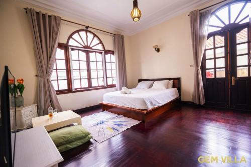 a bedroom with a bed and two windows at GEM VILLA 10 - 5 Bedroom, 6 Bathroom, Big Pool, Big Garden in Ho Chi Minh City