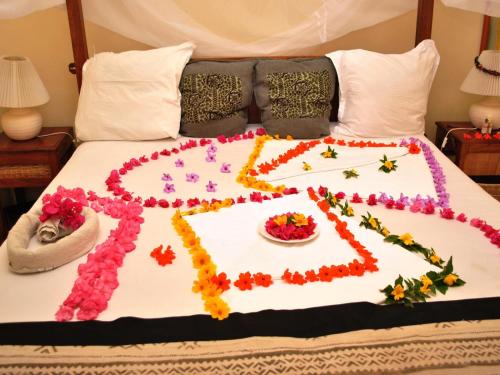 a bed with a flower decoration on it at Lemon Creek Hotel Resort in Bijilo