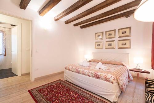 a white bedroom with a bed and a rug at San Marco New Romantic in Venice