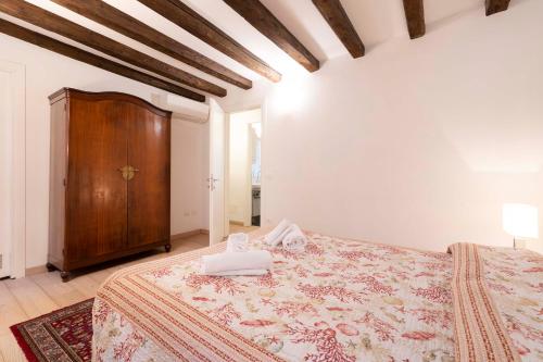 a bedroom with a large bed and a wooden cabinet at San Marco New Romantic in Venice