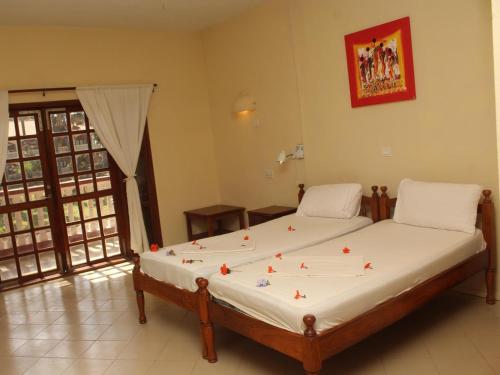 a bedroom with a large bed with flowers on it at Lemon Creek Hotel Resort in Bijilo