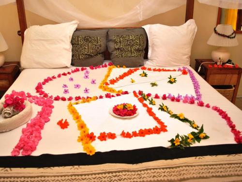 a bed with a flower decoration on it at Lemon Creek Hotel Resort in Bijilo