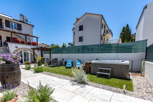 a backyard with a barbecue grill and a house at Apartments Mikulin Family in Punat
