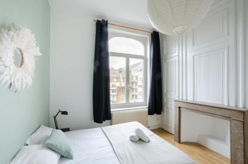 sypialnia z łóżkiem, kominkiem i oknem w obiekcie NOCNOC - Le jardin du prefet w Lille