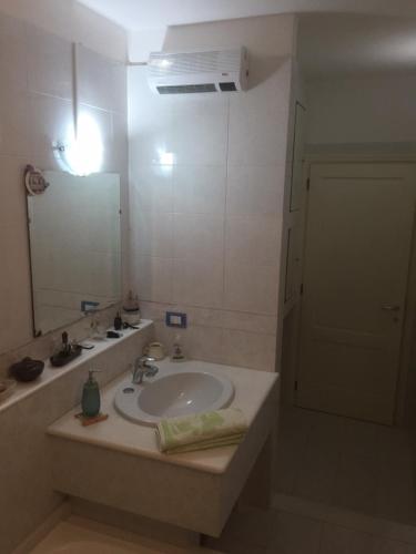a bathroom with a sink and a mirror at B&B Filomena in Santa Giusta