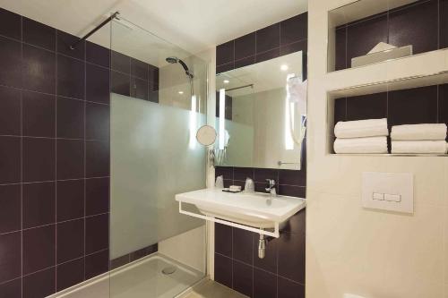 a bathroom with a sink and a mirror at Hôtel Brésil Opéra SPA in Paris